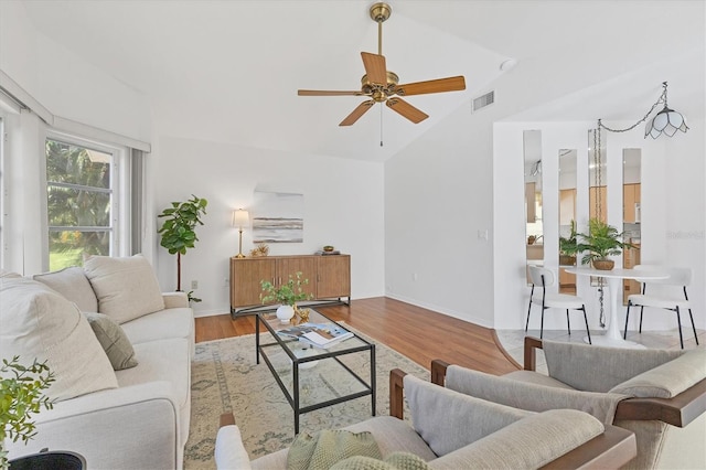 living room with ceiling fan, light hardwood / wood-style floors, and lofted ceiling