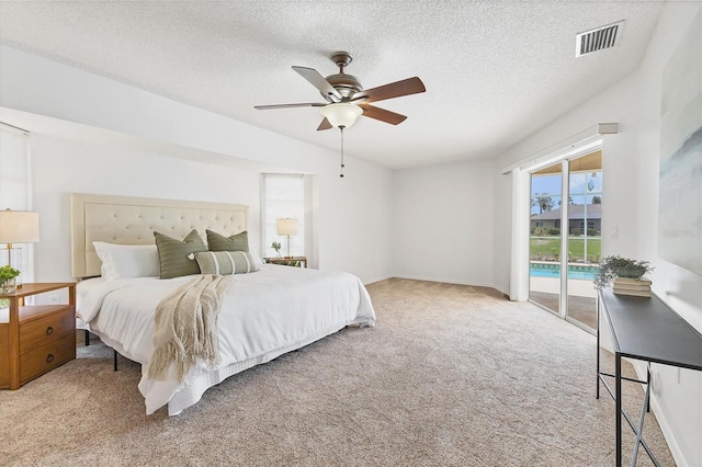 carpeted bedroom with access to exterior, a textured ceiling, vaulted ceiling, and ceiling fan