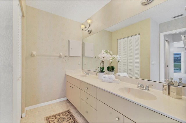 bathroom featuring a textured ceiling, vanity, and tile patterned floors