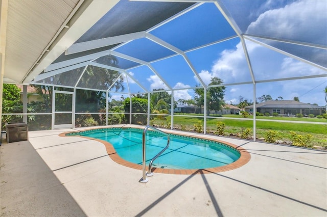 view of pool with glass enclosure and a patio area