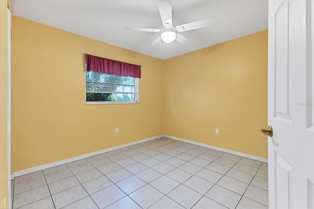 tiled spare room with ceiling fan