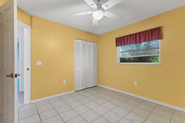 unfurnished bedroom with ceiling fan, a closet, and light tile patterned floors