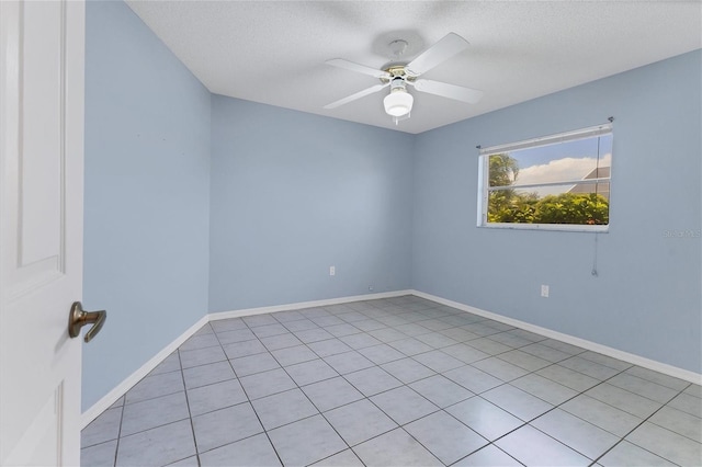 tiled spare room featuring a textured ceiling and ceiling fan