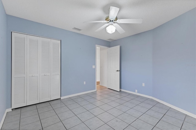 unfurnished bedroom with light tile patterned floors, a closet, and ceiling fan