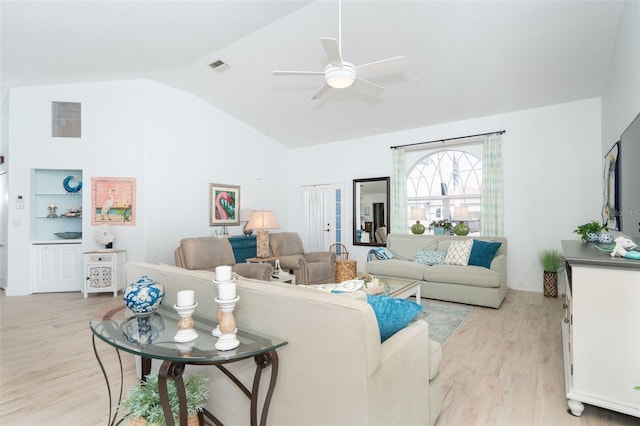 living room with ceiling fan, light hardwood / wood-style floors, and vaulted ceiling