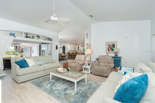 living room featuring ceiling fan with notable chandelier, light hardwood / wood-style flooring, and lofted ceiling