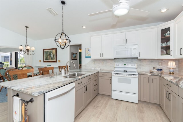 kitchen featuring white cabinets, white appliances, hanging light fixtures, and sink