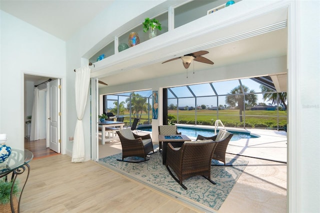 view of patio / terrace with a fire pit, ceiling fan, and a lanai