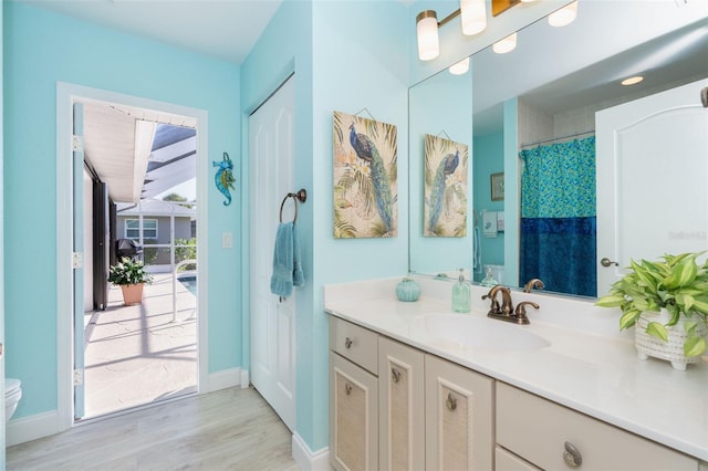 bathroom featuring wood-type flooring, vanity, and toilet