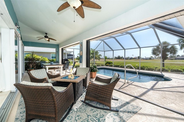 view of patio / terrace featuring glass enclosure, ceiling fan, and a fire pit