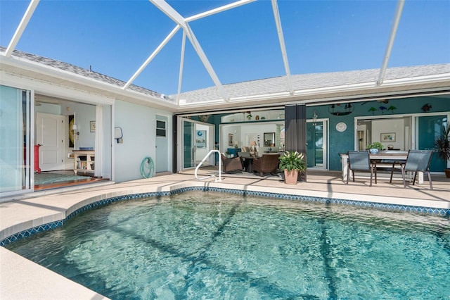 view of swimming pool featuring glass enclosure and a patio area