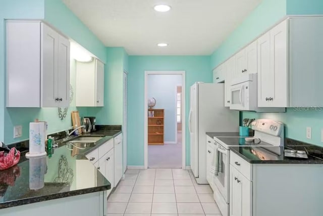 kitchen with sink, white cabinets, light tile patterned flooring, and white appliances