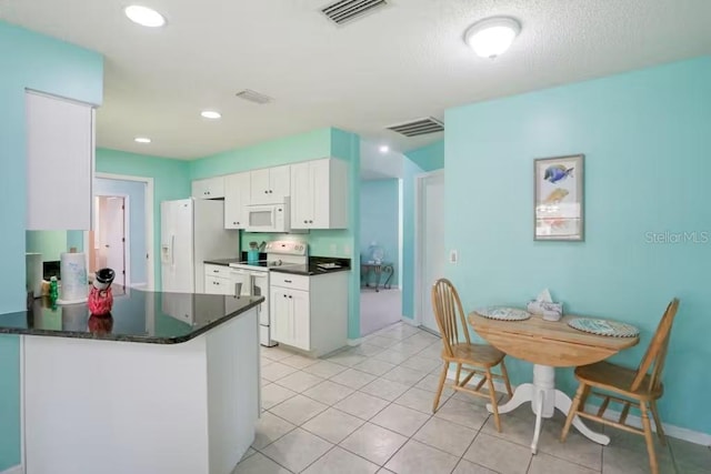 kitchen featuring kitchen peninsula, white cabinetry, light tile patterned flooring, and white appliances