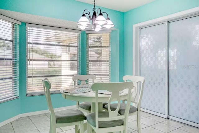 tiled dining space with a chandelier