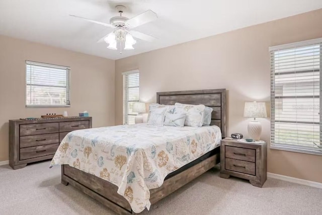 carpeted bedroom with multiple windows and ceiling fan