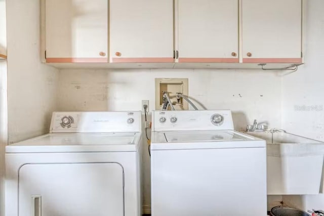 clothes washing area with cabinets, separate washer and dryer, and sink