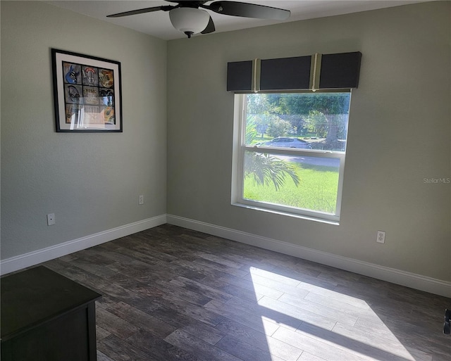 empty room with dark wood-type flooring, ceiling fan, and baseboards