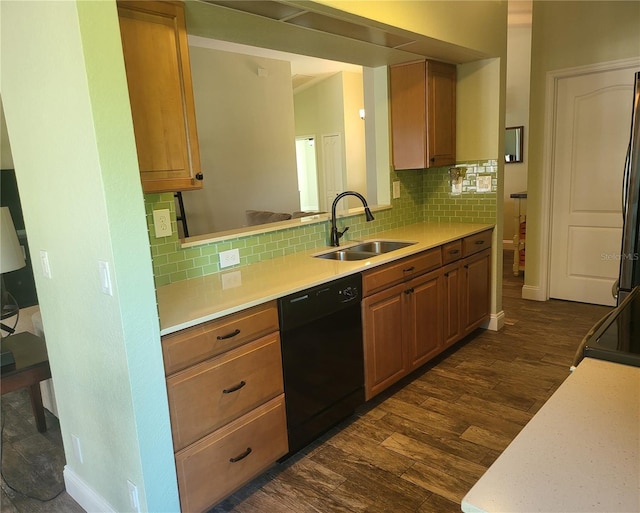 kitchen with black dishwasher, light countertops, a sink, and dark wood-style flooring