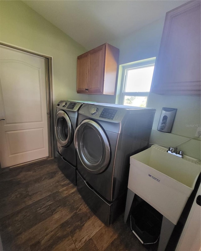 laundry area featuring dark hardwood / wood-style floors, washer and dryer, and cabinets