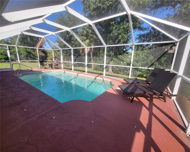 view of swimming pool with glass enclosure and a patio area