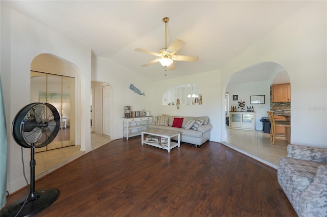 living room with hardwood / wood-style flooring, ceiling fan, and lofted ceiling