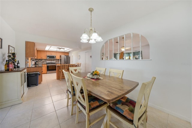 dining area featuring sink and light tile patterned flooring