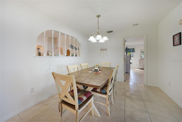 dining space with an inviting chandelier and light tile patterned flooring