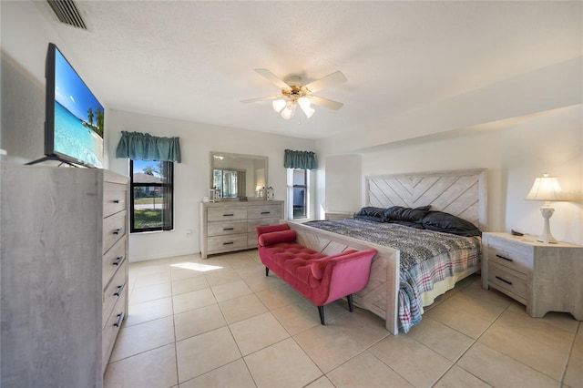 tiled bedroom featuring ceiling fan and a textured ceiling