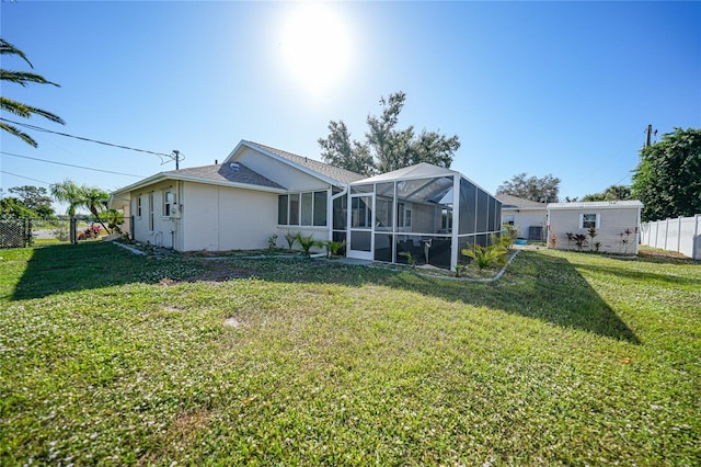 back of property with a lanai and a lawn