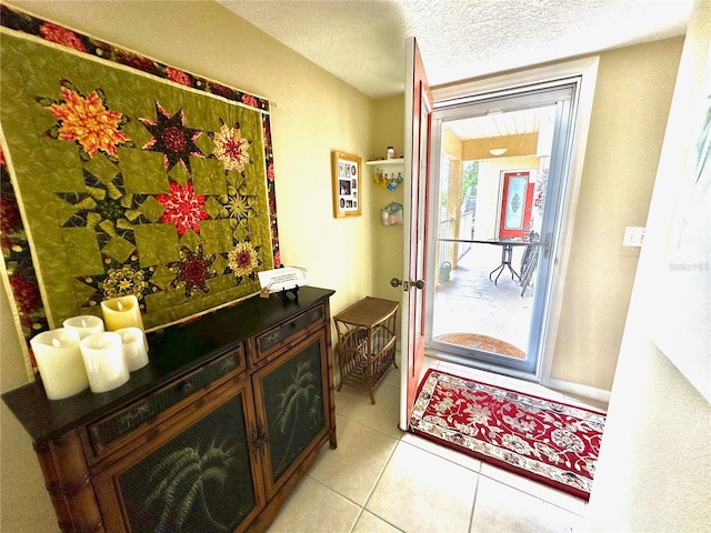 entrance foyer with light tile patterned floors and a textured ceiling