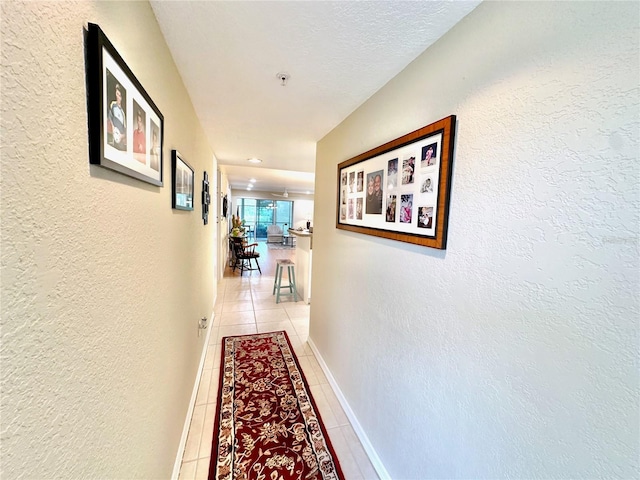 hallway with light tile patterned floors and a textured ceiling