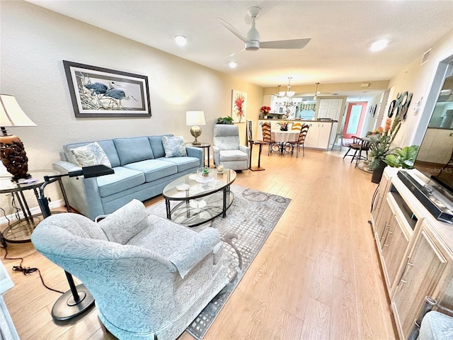 living room with ceiling fan and light hardwood / wood-style flooring