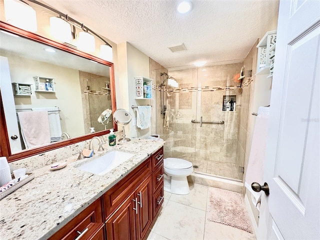 bathroom featuring tile patterned flooring, vanity, an enclosed shower, a textured ceiling, and toilet