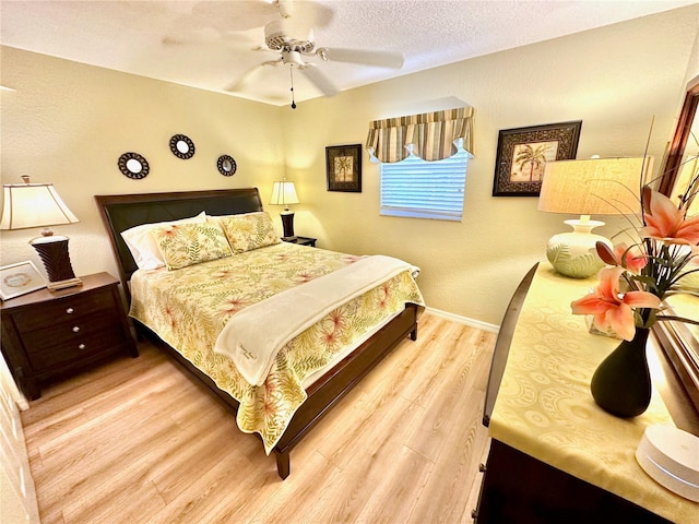 bedroom with ceiling fan, a textured ceiling, and light wood-type flooring