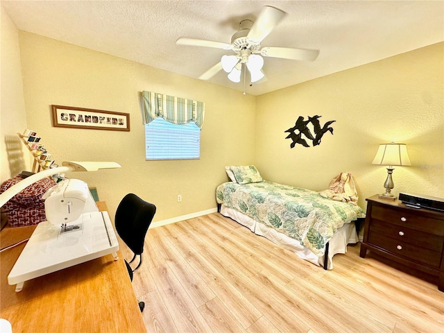 bedroom with ceiling fan, light hardwood / wood-style floors, and a textured ceiling