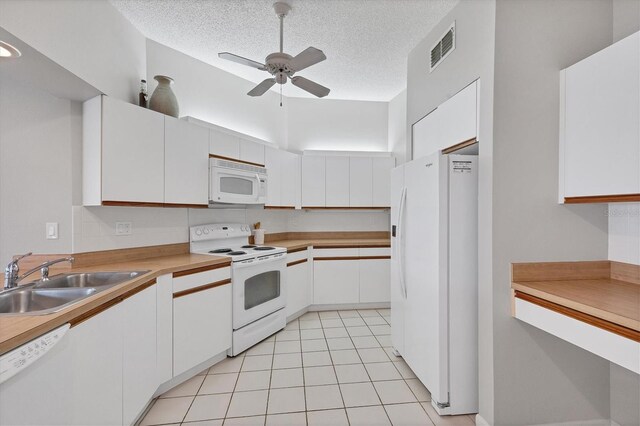 kitchen with a textured ceiling, white appliances, ceiling fan, sink, and white cabinetry