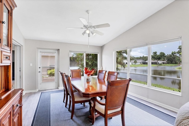 sunroom featuring ceiling fan, a water view, a healthy amount of sunlight, and lofted ceiling