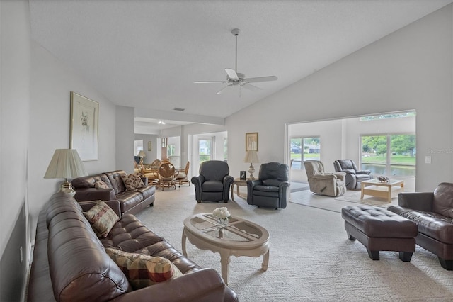 carpeted living room with a textured ceiling, high vaulted ceiling, and ceiling fan