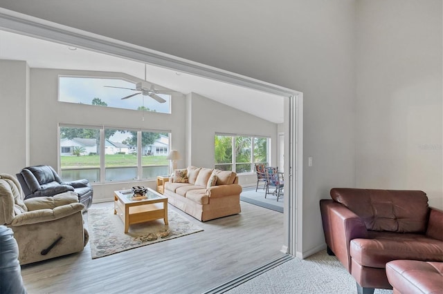 living room featuring a water view, ceiling fan, and lofted ceiling