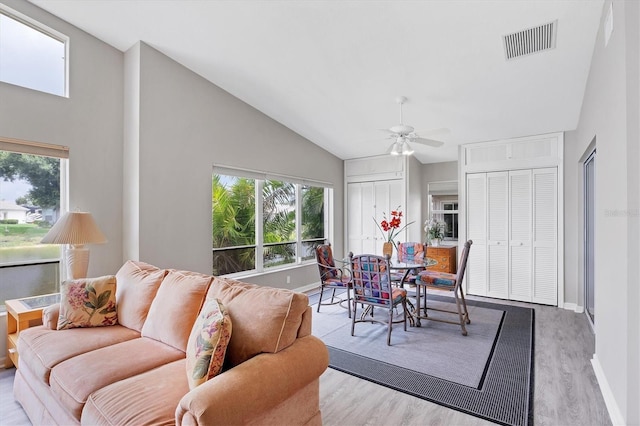 living room featuring vaulted ceiling, light hardwood / wood-style flooring, plenty of natural light, and ceiling fan