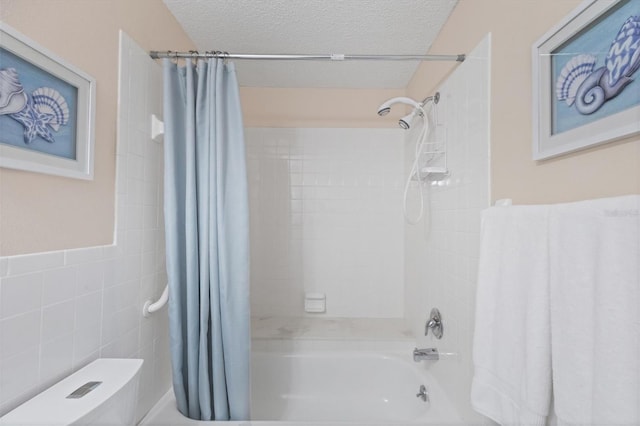 bathroom with toilet, shower / bathtub combination with curtain, a textured ceiling, and tile walls