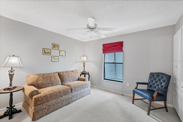 carpeted living room featuring ceiling fan and a textured ceiling