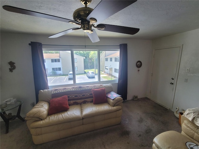 carpeted living room with ceiling fan and a textured ceiling