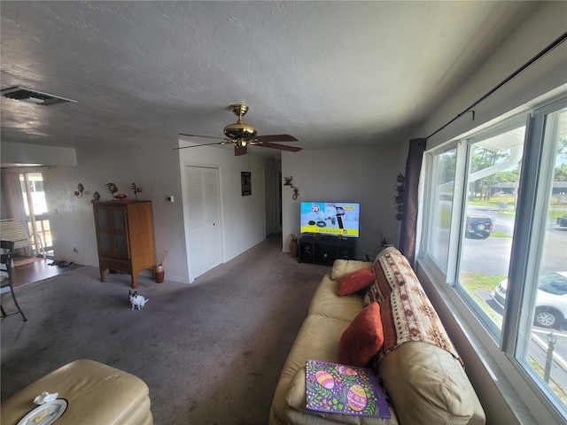 carpeted living room featuring plenty of natural light, ceiling fan, and a textured ceiling