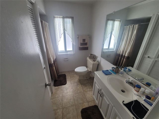 bathroom featuring a wealth of natural light, toilet, tile floors, and large vanity