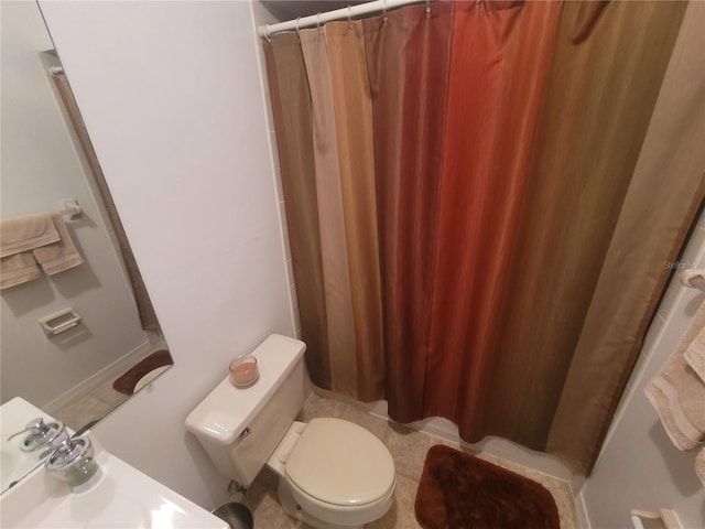 bathroom with tile flooring and toilet