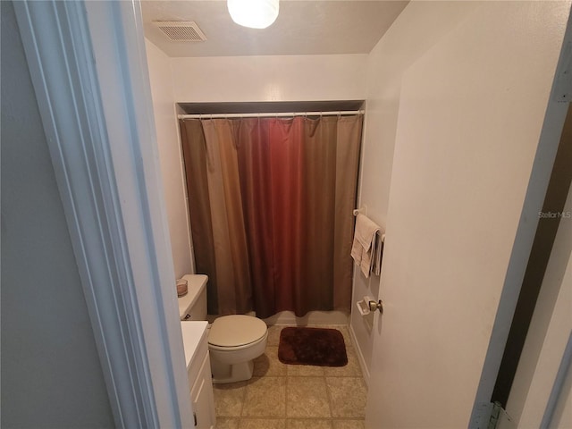 bathroom with tile flooring, vanity, and toilet