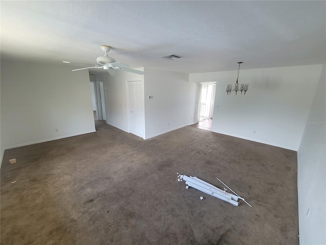 spare room featuring ceiling fan with notable chandelier