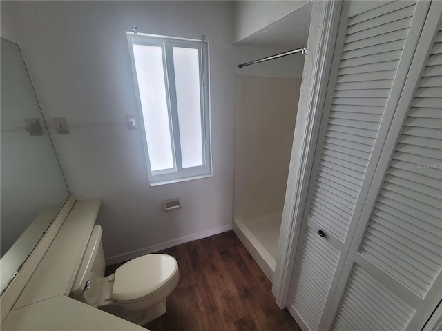 bathroom featuring toilet, hardwood / wood-style flooring, and a shower