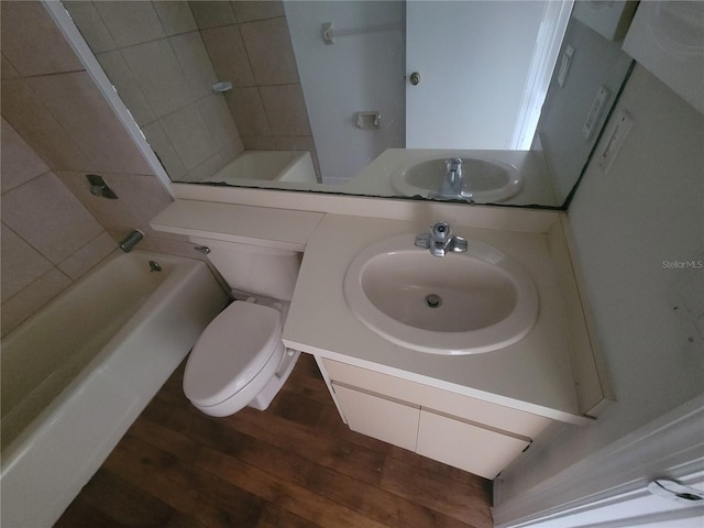 full bathroom featuring tiled shower / bath combo, toilet, oversized vanity, and hardwood / wood-style floors